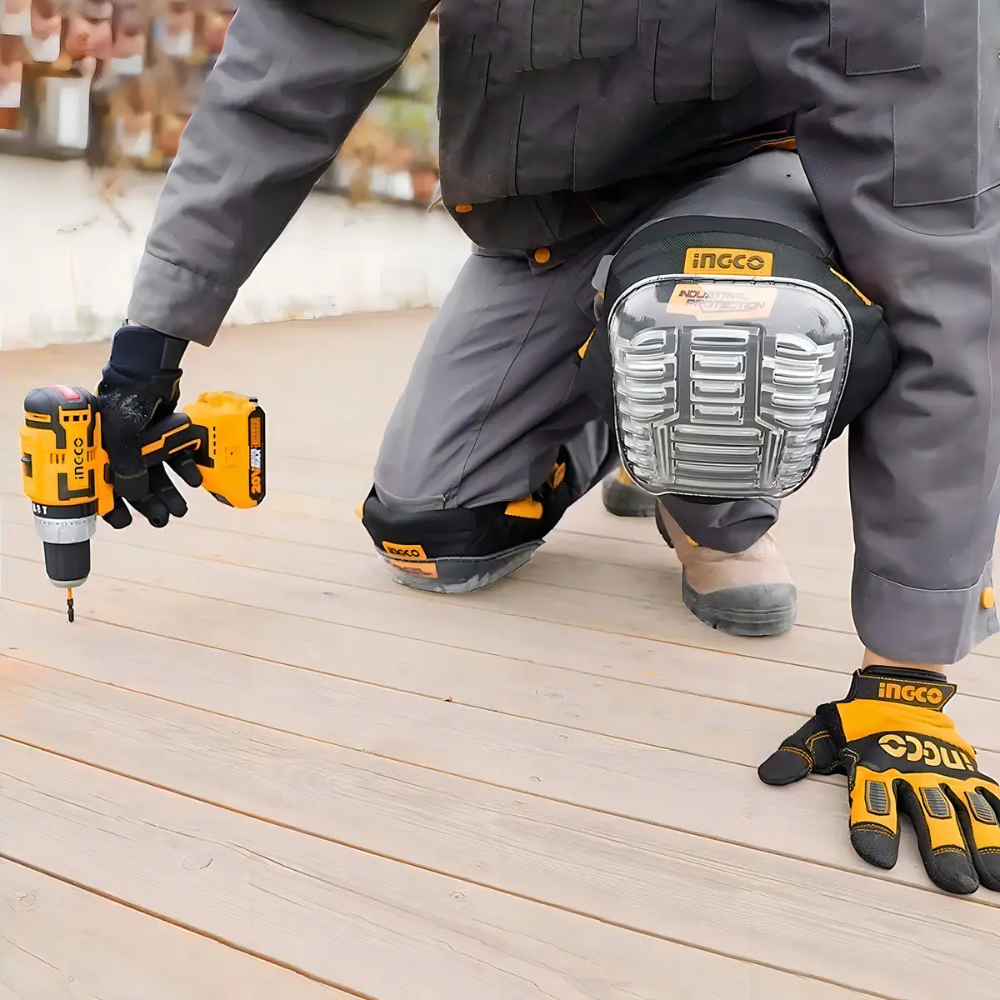 Trabajador arrodillado usando las rodilleras Ingco HKPT0101 sobre un piso de madera