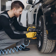 Compresor Ingco AC255016 usado con llave de impacto neumática en la rueda de un auto
